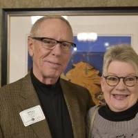 Two alumni smiling together at the event.